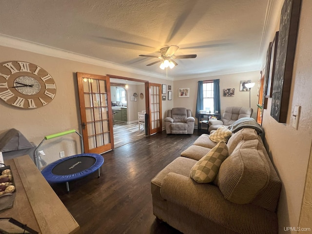 living room featuring french doors, ceiling fan, wood finished floors, crown molding, and a textured ceiling