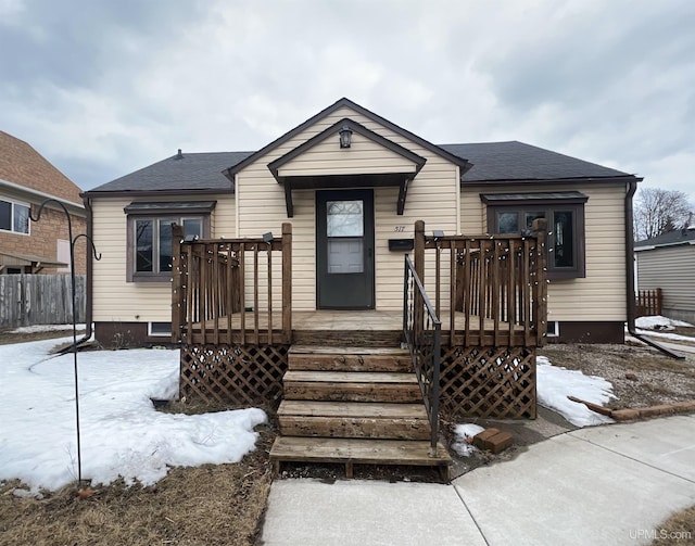 view of front of home featuring roof with shingles and fence