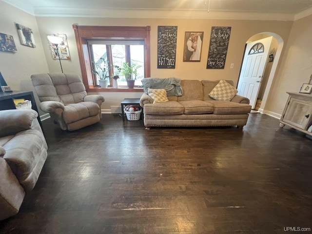 living area with dark wood-style floors, baseboards, arched walkways, and crown molding