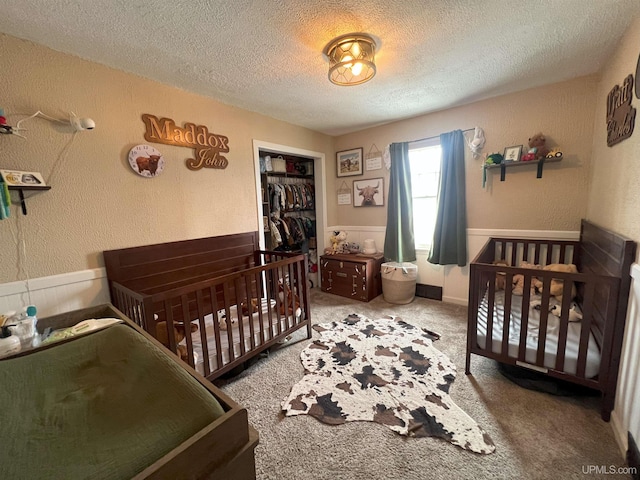 bedroom featuring a closet, carpet flooring, a textured wall, and a textured ceiling