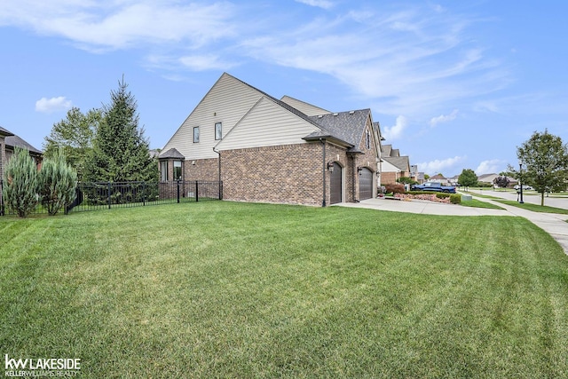 view of home's exterior featuring an attached garage, brick siding, fence, driveway, and a yard