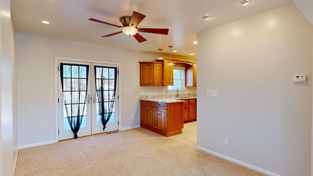 kitchen with recessed lighting, light colored carpet, baseboards, french doors, and brown cabinetry