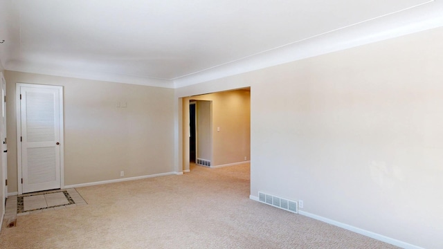 carpeted empty room featuring visible vents and baseboards