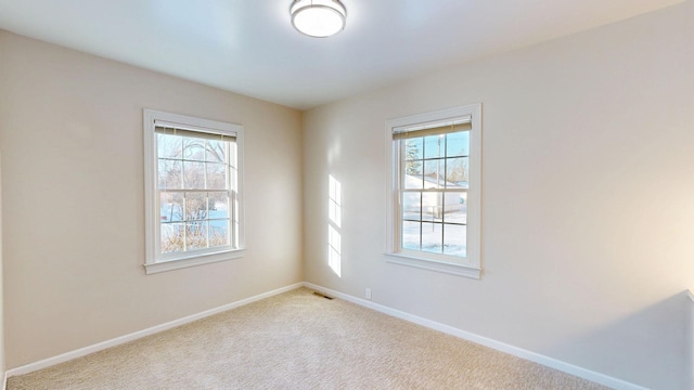 carpeted spare room with baseboards and visible vents