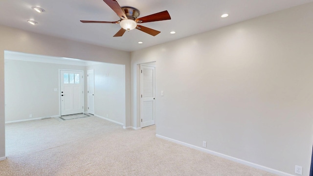 spare room with light carpet, ceiling fan, baseboards, and recessed lighting