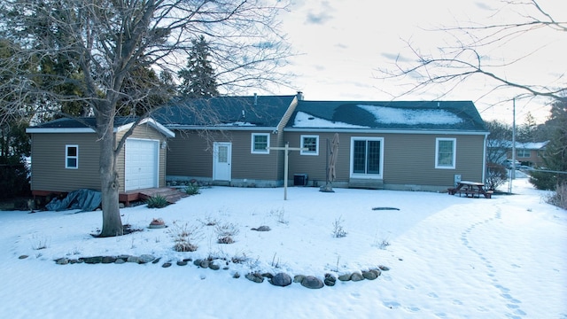 snow covered property with entry steps and an outdoor structure