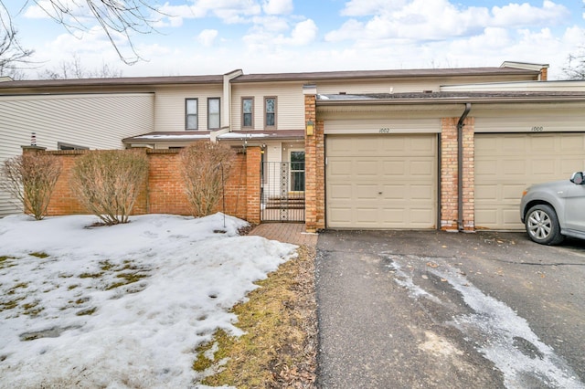 view of property with driveway and brick siding