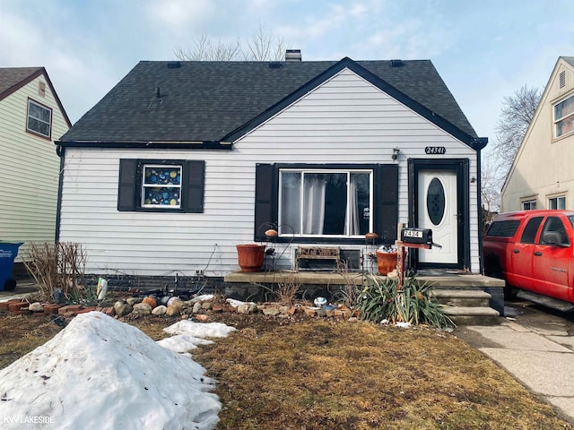 view of front of house with roof with shingles and a chimney