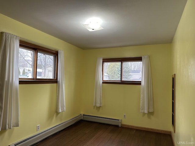 unfurnished room featuring a baseboard radiator, baseboards, and dark wood finished floors