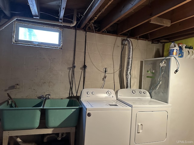 clothes washing area featuring washer and dryer, laundry area, and a sink