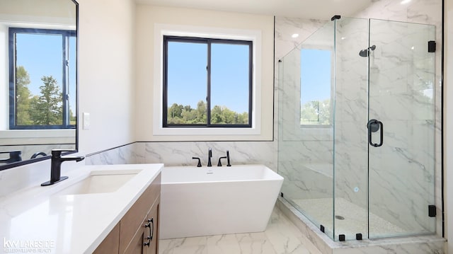 bathroom featuring marble finish floor, a soaking tub, a marble finish shower, and vanity