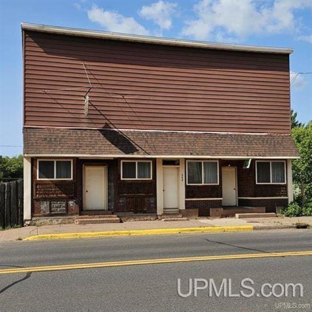 view of front of home featuring a shingled roof and fence