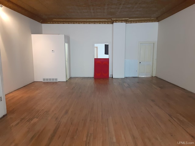 empty room featuring visible vents and hardwood / wood-style flooring