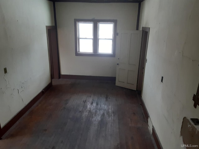 unfurnished room featuring baseboards and wood finished floors