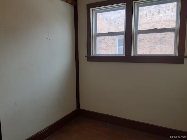 empty room featuring dark wood-type flooring and baseboards