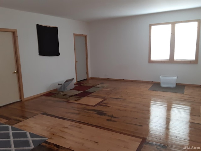 unfurnished room with baseboards and wood finished floors