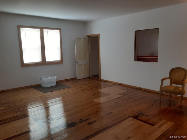 empty room featuring wood-type flooring and baseboards