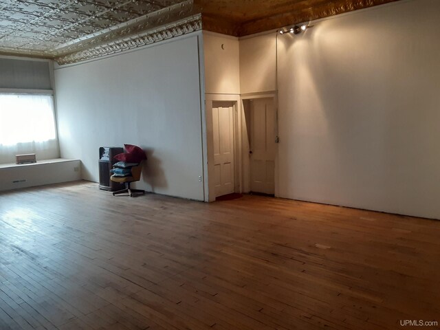 empty room with hardwood / wood-style flooring and an ornate ceiling