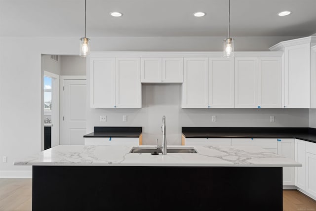 kitchen featuring recessed lighting, white cabinets, and a sink