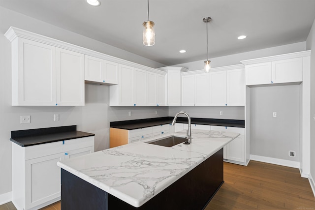 kitchen featuring recessed lighting, dark wood-style flooring, a sink, white cabinetry, and an island with sink