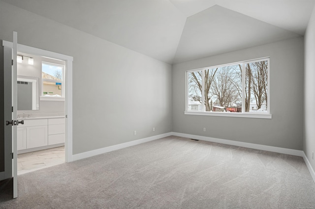 unfurnished room with vaulted ceiling, light carpet, visible vents, and baseboards