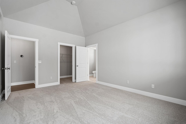 unfurnished bedroom featuring carpet, a spacious closet, and baseboards