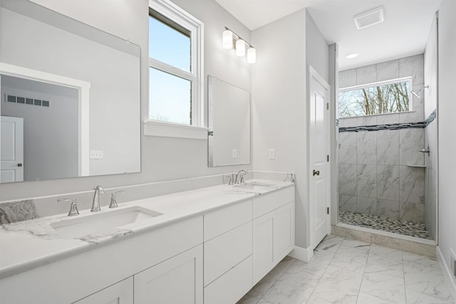 bathroom featuring marble finish floor, a shower stall, visible vents, and a sink