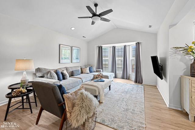 living area featuring vaulted ceiling, light wood-type flooring, and baseboards