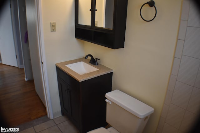 bathroom with tile patterned flooring, vanity, and toilet