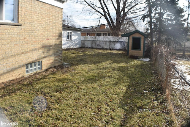 view of yard featuring an outbuilding, fence, and a shed