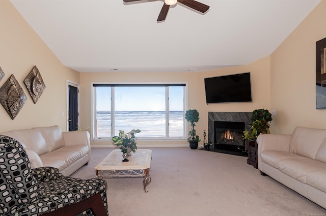 carpeted living room featuring a fireplace, baseboards, and ceiling fan