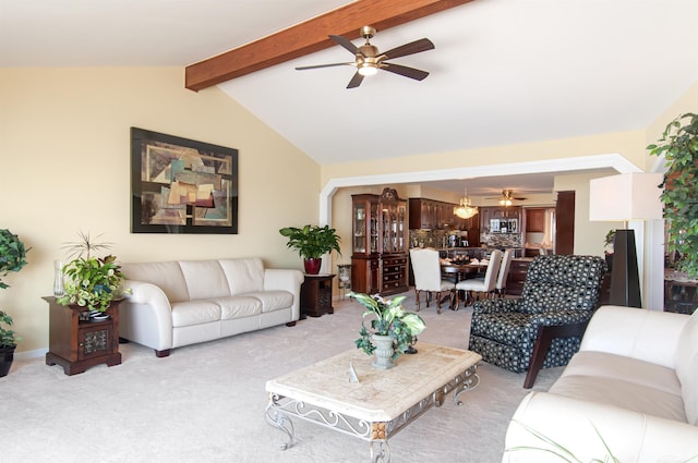 living area featuring a ceiling fan, light colored carpet, and vaulted ceiling with beams