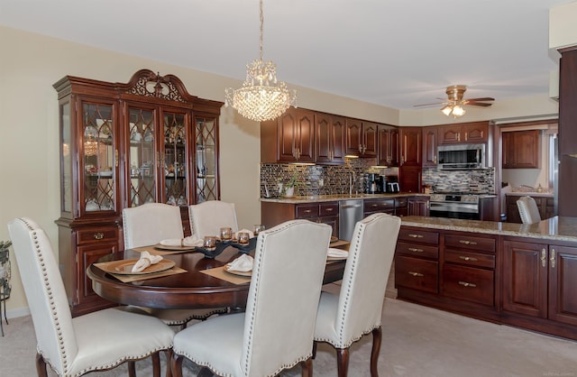 dining space featuring ceiling fan with notable chandelier