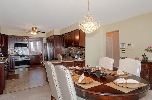 dining space featuring ceiling fan with notable chandelier