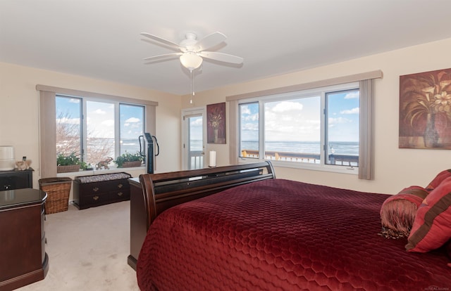 bedroom with access to exterior, a ceiling fan, and light colored carpet