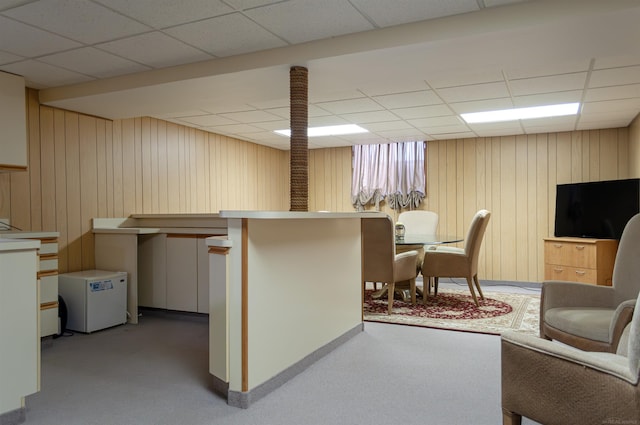 interior space with carpet floors, wood walls, and a paneled ceiling