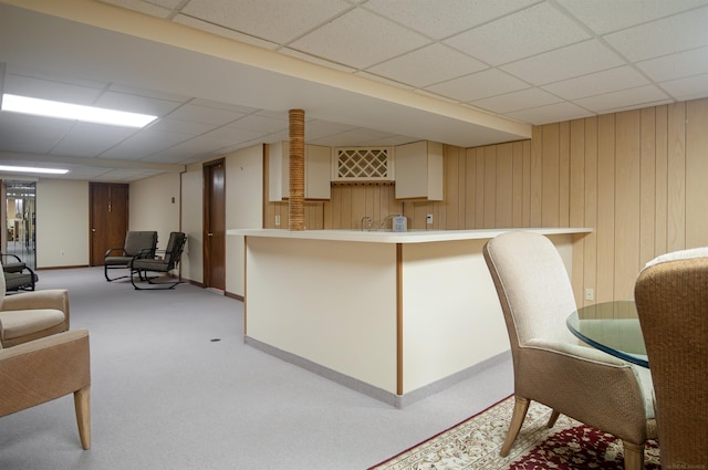 kitchen with a paneled ceiling and wooden walls