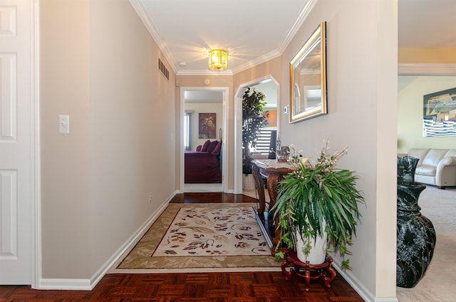 doorway with baseboards, visible vents, and ornamental molding