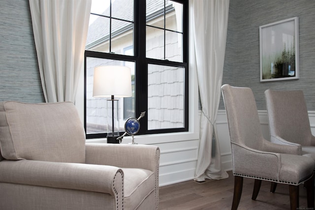 living area featuring wood finished floors and a decorative wall