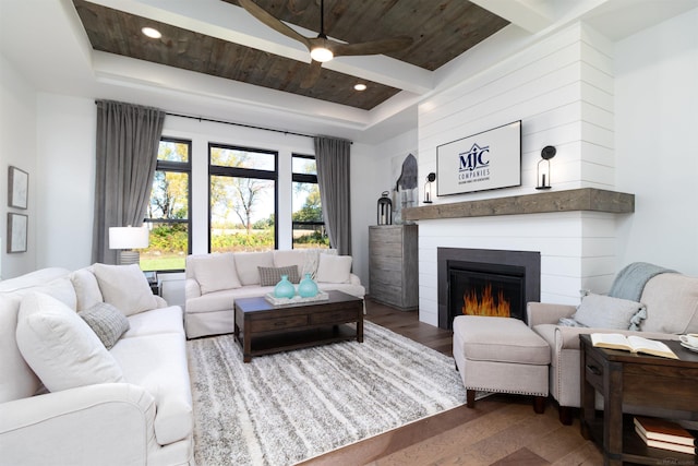 living room with a warm lit fireplace, wooden ceiling, recessed lighting, wood finished floors, and beamed ceiling