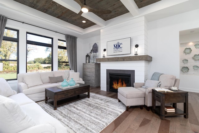 living area featuring ceiling fan, recessed lighting, a fireplace, wood finished floors, and beam ceiling