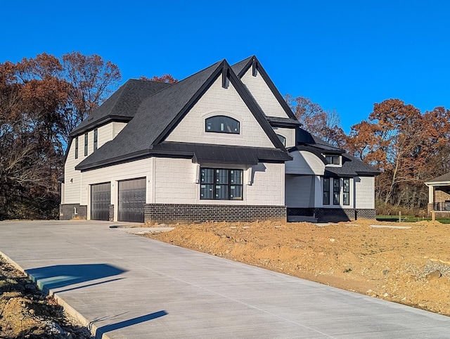 view of front of property with a garage, driveway, and brick siding