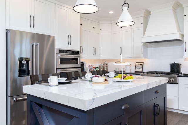 kitchen featuring appliances with stainless steel finishes, custom exhaust hood, white cabinets, and a center island