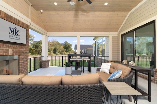 wooden terrace with an outdoor living space with a fireplace and outdoor dining area