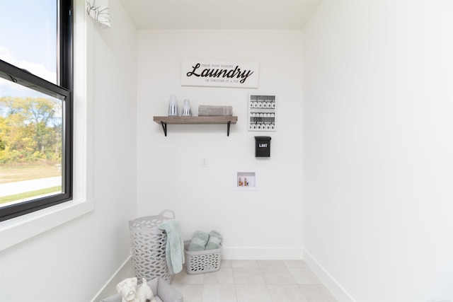 washroom featuring laundry area, washer hookup, light tile patterned flooring, and baseboards