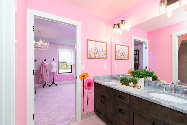 full bath featuring double vanity, a sink, and baseboards