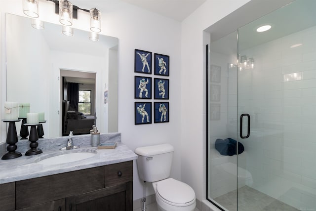 bathroom with a shower stall, toilet, and vanity