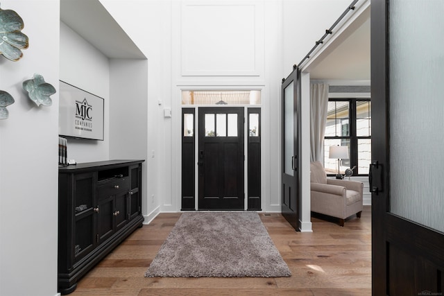 foyer with light wood-style floors and a barn door