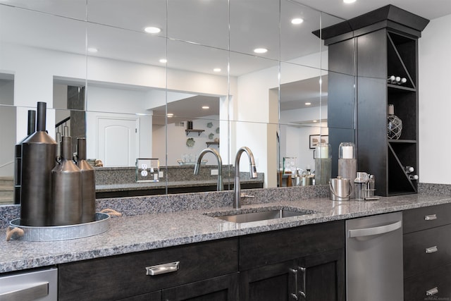 kitchen featuring light stone counters, recessed lighting, a sink, and stainless steel dishwasher