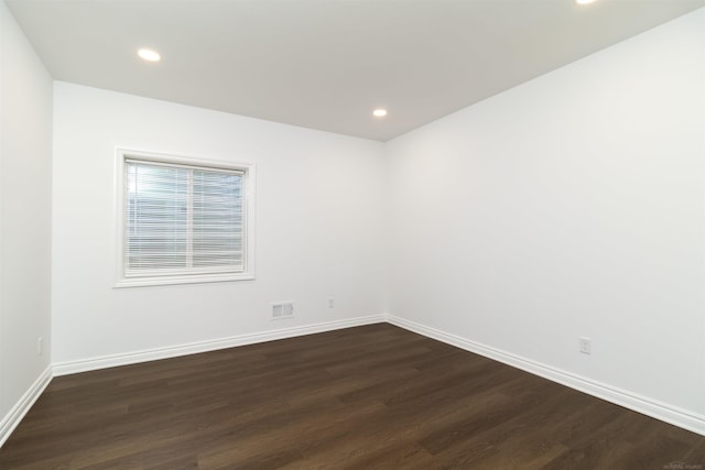 unfurnished room featuring visible vents, baseboards, dark wood-type flooring, and recessed lighting